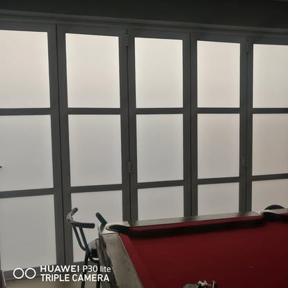 Frosted folding glass partition inside a games room